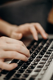 Manos en teclado de ordenador escribiendo