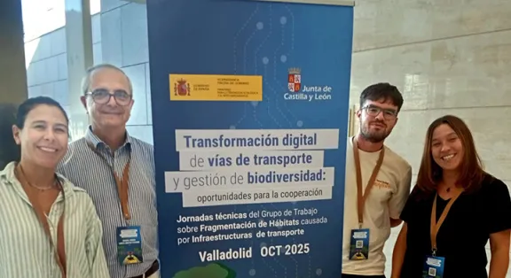 cuatro técnicos del CEDEX posan junto a un roll up sobre ingeniería ambiental